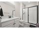 Bathroom with patterned tile, white vanity, black hardware, and a glass enclosed shower at 2766 Keepsake Way, Castle Rock, CO 80109