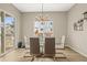 Contemporary dining room with a glass table, modern chandelier, and views of the outdoors at 2766 Keepsake Way, Castle Rock, CO 80109