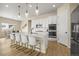 Well-lit kitchen showcases a large island with barstool seating, stainless appliances, and white cabinets at 2766 Keepsake Way, Castle Rock, CO 80109