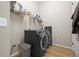 Practical laundry room equipped with modern washer and dryer, laminate floors, and shelving for organized storage at 2766 Keepsake Way, Castle Rock, CO 80109