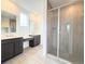 Bathroom featuring double vanity sinks, walk-in shower with glass doors, and tile flooring at 3967 Descent St, Castle Rock, CO 80108