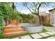 Serene backyard featuring lush landscaping, a wooden deck, and metal stock tank pool at 659 Albion St, Denver, CO 80220