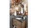 This powder room features a wood vanity, black countertop, modern sink, and floral wallpaper at 659 Albion St, Denver, CO 80220