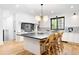 This open kitchen with hardwood floors has a black countertop island with seating and stainless steel appliances at 659 Albion St, Denver, CO 80220