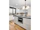 The white kitchen features stainless appliances, an oven, white cabinets and drawers, and hardwood floors at 659 Albion St, Denver, CO 80220