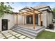 Staged patio with a wooden pergola, string lights, large glass doors, and backyard grass pavers at 659 Albion St, Denver, CO 80220