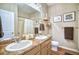 Well-lit bathroom featuring a double vanity, framed pictures, and neutral accents at 6221 N Easton Ave, Frederick, CO 80504