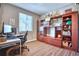 The rustic home office features wood laminate flooring and built-in shelving and storage at 6221 N Easton Ave, Frederick, CO 80504