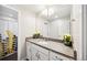 Bright bathroom featuring a large mirror, white cabinetry, and a shower with modern tile at 5965 Hanover St, Denver, CO 80238