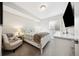 Comfortable bedroom with a white bed frame, soft carpet, chair, and a television at 5965 Hanover St, Denver, CO 80238