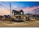 Charming two-story home with a covered front porch and landscaped front yard at sunset at 5965 Hanover St, Denver, CO 80238