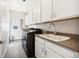 This laundry room features modern appliances and ample storage within its bright, white cabinets at 5965 Hanover St, Denver, CO 80238