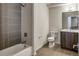 Bathroom with gray tiled walls, soaking tub, and modern vanity with a granite countertop at 3408 W 18Th Ave, Denver, CO 80204