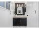 Modern powder bathroom with a gold-framed mirror, black vanity, and white marble floors at 7586 Halleys Dr, Littleton, CO 80125