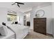 Bedroom featuring carpet, a ceiling fan, a large window, and a wooden dresser at 7586 Halleys Dr, Littleton, CO 80125