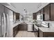 Well-lit kitchen features stainless steel appliances, contrasting cabinets, and a view of the backyard at 7586 Halleys Dr, Littleton, CO 80125