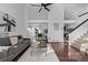 Open concept living room with hardwood floors and stairs, flowing into adjacent dining room at 7586 Halleys Dr, Littleton, CO 80125