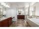 A primary bathroom featuring dual vanities, a soaking tub, and a glass-enclosed shower at 27029 E Irish Pl, Aurora, CO 80016