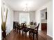 Inviting dining room features hardwood floors and a stylish chandelier over the dark wood table set for six at 27029 E Irish Pl, Aurora, CO 80016