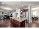 Open-concept kitchen with a central island seamlessly connecting to the adjacent living spaces at 27029 E Irish Pl, Aurora, CO 80016