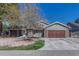 Attractive home featuring a two-car garage, brick accents and a mix of green and brown siding, enhancing curb appeal at 7444 S Milwaukee Ct, Centennial, CO 80122