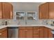 Bright kitchen featuring light countertops, a stainless steel dishwasher, and ample cabinet space, perfect for home cooking at 7444 S Milwaukee Ct, Centennial, CO 80122