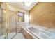 Modern bathroom featuring a soaking tub, glass shower, and scenic view at 6601 Pike Cir, Larkspur, CO 80118