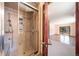 Bathroom shower featuring tile and glass door, with a view into an adjacent room at 6601 Pike Cir, Larkspur, CO 80118