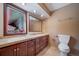 Cozy bathroom with a large vanity, wood cabinets, a big mirror, and warm lighting at 6601 Pike Cir, Larkspur, CO 80118