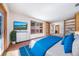 Bright bedroom featuring built-in shelving, a large window, and a comfortable, modern style with a TV at 6601 Pike Cir, Larkspur, CO 80118