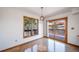 Dining area with hardwood floors, a modern chandelier, and natural views through sliding door access to the deck at 6601 Pike Cir, Larkspur, CO 80118