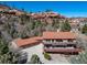 Two-story home with an attached three car garage, a red tiled roof, wooden decks and green siding at 6601 Pike Cir, Larkspur, CO 80118