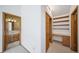 Hallway featuring access to a bathroom and a study nook with wooden shelves and cabinets at 6601 Pike Cir, Larkspur, CO 80118