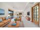 Bright living room with sliding glass doors, comfortable seating, and carpeted floors at 6601 Pike Cir, Larkspur, CO 80118