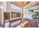 Spacious living room with high ceilings, terracotta floors, a fireplace, and a large window at 6601 Pike Cir, Larkspur, CO 80118