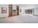 Spacious living room with fireplace, built-in shelves, and sliding doors to the balcony at 6601 Pike Cir, Larkspur, CO 80118