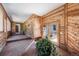 Enclosed sunroom with brick flooring, wood paneled walls, large windows and a glass paneled exterior door at 6601 Pike Cir, Larkspur, CO 80118