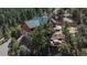 Home exterior featuring large deck, a lush surrounding of tall trees, and a nearby hot tub at 804 Clear Creek Rd, Evergreen, CO 80439