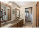 Bathroom with dual sinks, wood framed mirrors, and access to shower and closet at 804 Clear Creek Rd, Evergreen, CO 80439