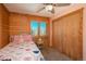 A quaint bedroom featuring wood paneling, pink accents, and a large closet with wooden sliding doors at 804 Clear Creek Rd, Evergreen, CO 80439