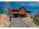 View of the home showing garage access, deck, and well-maintained yard at 804 Clear Creek Rd, Evergreen, CO 80439