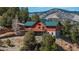 Exterior shot showcasing the house's wraparound deck and well-maintained yard at 804 Clear Creek Rd, Evergreen, CO 80439