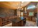 Charming rustic kitchen with custom cabinets, arched windows, and a unique island with seating for one at 804 Clear Creek Rd, Evergreen, CO 80439