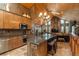 Spacious kitchen boasts wood cabinets, stainless appliances, and a granite-topped island with bar stool seating at 804 Clear Creek Rd, Evergreen, CO 80439