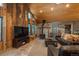 Open living room features wood walls, a cozy fireplace, and views from the many windows at 804 Clear Creek Rd, Evergreen, CO 80439