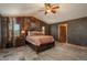 Comfortable main bedroom with ensuite bathroom, ceiling fan, and rustic accent wall at 804 Clear Creek Rd, Evergreen, CO 80439