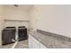 Convenient laundry room with washer, dryer, and granite countertop at 6506 Barnstead Dr, Castle Pines, CO 80108