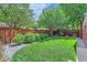 Well-maintained backyard with lush green lawn, mature trees, and a privacy fence at 1218 S Josephine St, Denver, CO 80210