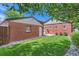 Landscaped backyard with grass, stone pathway and mature plantings surrounding a brick building at 1218 S Josephine St, Denver, CO 80210