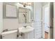 Classic bathroom featuring a pedestal sink, vintage mirror, and white wainscoting for a clean, timeless look at 1218 S Josephine St, Denver, CO 80210